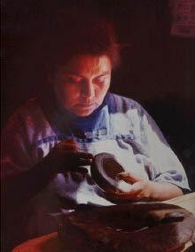 Phoro of Hopi Mesa Native American Potter working in her home, photo copyrighted 2005, all rights reserved.
